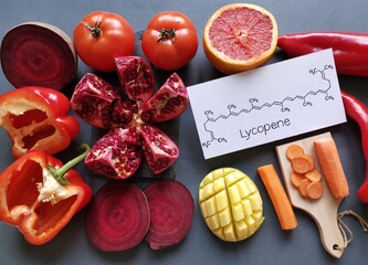 Foods rich in lycopene with structural chemical formula of lycopene molecule. Natural sources of lycopene: tomato, grapefruit, pomegranate, red bell pepper, beetroot, mango and carrot.