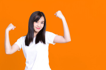 Asian gorgeous strong young pin-up woman smiling isolated over background wall showing biceps screaming.