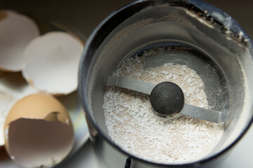 Grinding eggshells to an electric coffee grinder.