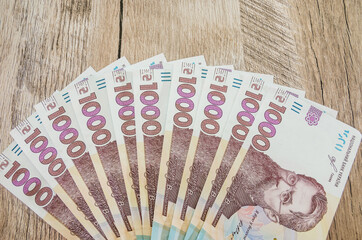 1000 hryvnia on a wooden background.