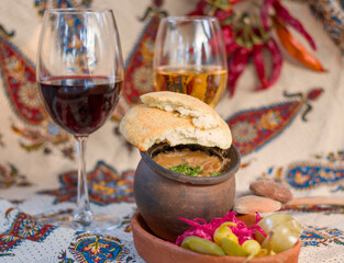 Georgian traditional food Lobio or kidney and haricot beans soup with picked vegetables and red wine.