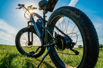 Electric bicycle with thick wheels in nature. Fatbike close-up