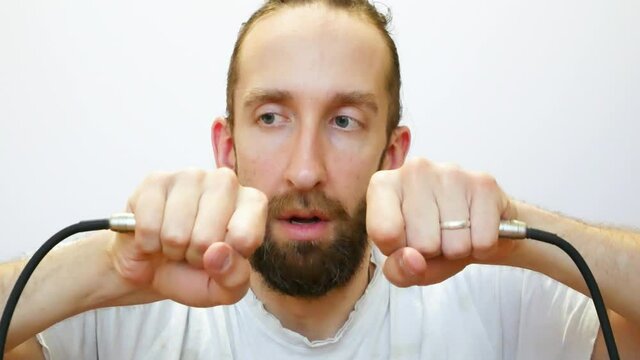 A cute bearded man is shocked when he connects two wires