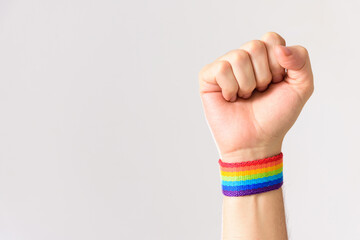 closed fist against homophobia. closed fist with colorful rainbow flag wristbands. Proud gay man....