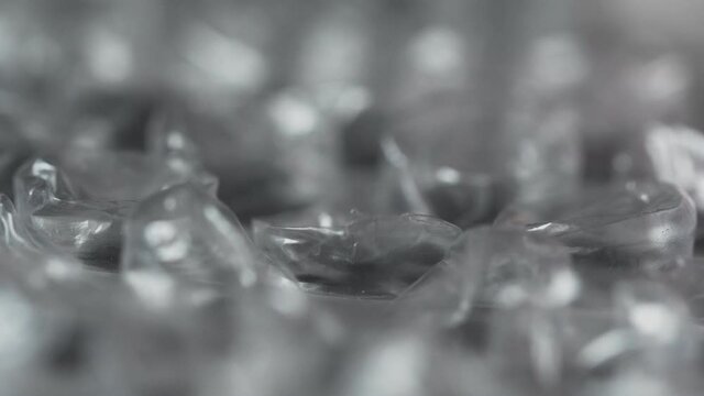 Finger pops bubble by clicking on wrap film plastic packaging material, macro. Nervous system concept. Type of tactile amusement playing. Calming effect. Give pleasure. Satisfaction. Polyethylene