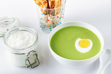 Cream-soup from broccoli cabbage with egg, sour cream and grissini. For menu. Selective focus.