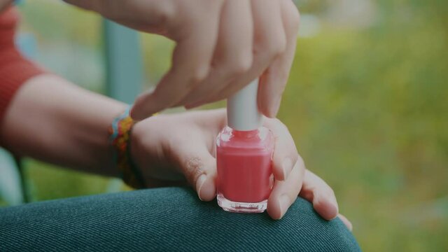 Hands Of A Woman Opening Pink Nail Polish Bottle
