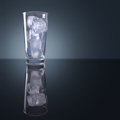 Several square ice cubes in a cylindrical clear glass placed on a polished surface with reflection ( This glass isolated with clipping path)