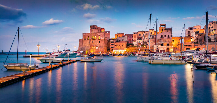 Panoramic evening cityscape of Castellammare del Golfo town. Calm summer seascape of Mediterranean sea. Picturesque scene of Sicily, Trapani Province, Europe. Traveling concept background.