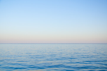 Obraz premium Seascape background calm sea and clear colorful sky at sunset