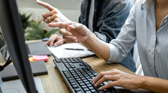 Two professional programmer cooperating and working on web site project in a software developing on desktop computer at company, codes and typing data code, Programming with HTML, PHP and javascript