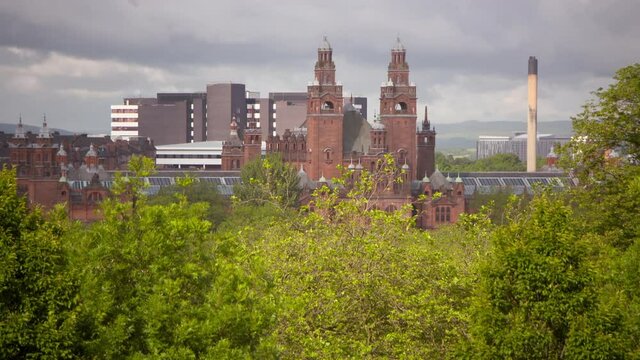 Lockdown shot of famous museum building in city against sky seen from Kelvingrove Park on sunny day - Glasgow, Scotland