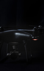 black drone and silver camera on black background