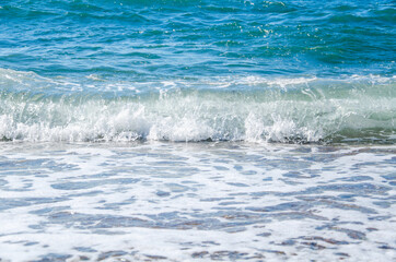 Naklejka na ściany i meble Seascape background white waves on blue sea