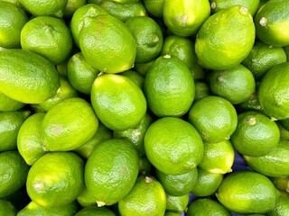 Green lime citrus fruits in market. Lime background.
