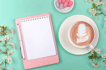 Creative flat lay of workspace desk, notepad and lifestyle objects on green background