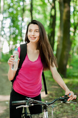 Female cyclist on a bike, with bottle of water, drink, sport women in the forest