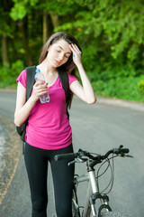 Female cyclist with bottle of water, drink and on a bike, sport women in the forest
