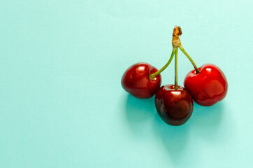 Obraz na płótnie Canvas red cherries on a blue background