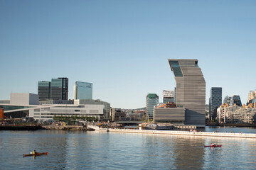 Fototapeta premium Panorama view on Oslo downtown. Sunny summer day, people enjoying sun, view on Oslo Opera House, sea and new Munch museum.