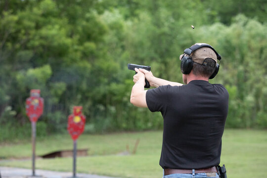 Man shooting with a gun at the outdoor range