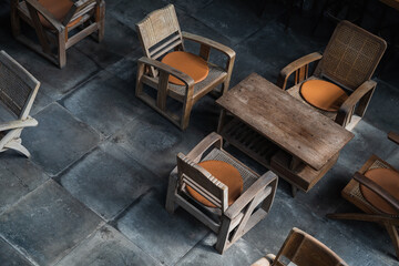 Fototapeta na wymiar Top view of wood tables and chairs in room on dark floor background