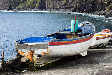Old colourful wooden boats with peeling paint. Azorean island old harbour.