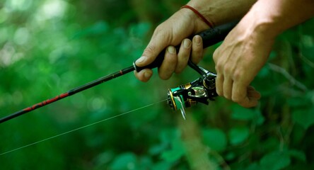 Canne à pêche - main pêcheur - moulinet  © mathisprod
