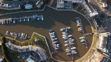 Private neighborhood with lagoon in the middle. Large yachts are seen in its port.
