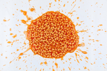 Baked beans splattered in a mess on a white background. 