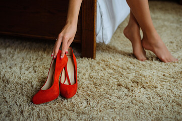 Elegant red high heels shoes in woman hands.