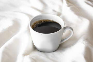 Morning Cup of Black Coffee on Bed Sheets