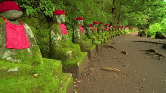The Narabi-Jizo statues are seen in a forested area of Nikko, Japan.