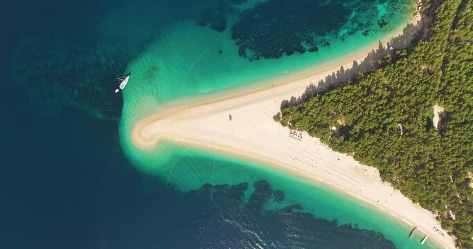 A bird's-eye-view shows boats anchored by Zlatni Rat Beach on Brac Island, Croatia.