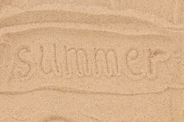 Fototapeta na wymiar Summer is written in the sand. Sandy beach for background. Summer background