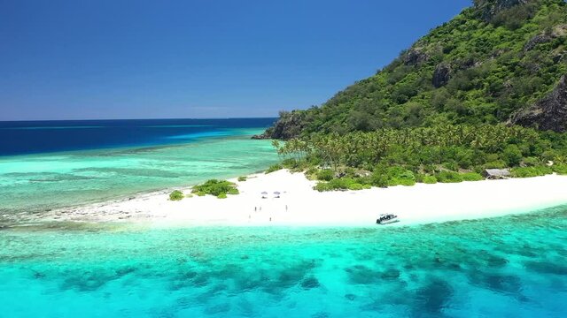 Tourists enjoy the beach and boats are seen anchored near Monuriki Island, Fiji.