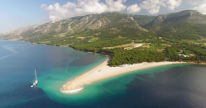 An aerial view shows Zlatni Rat Beach and its surrounding mountains on Brac Island, Croatia.