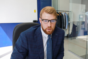 red-haired man in a suit in the office in the meeting room