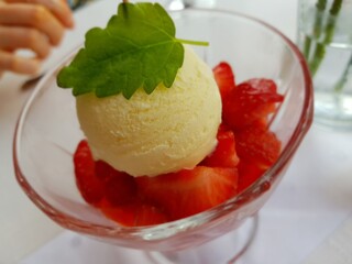 ice cream on a bed of strawberries with a mint leaf