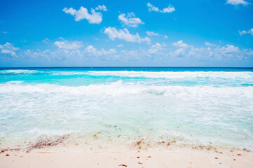 Fototapeta na wymiar tropical beach with blue sky. white sand, turqouise ocean and waves. Mexico, Cozumel island. 