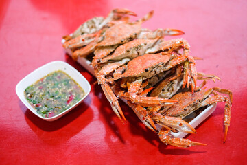 The steamed crab (claws) serve on white dish with spicy sauce- homemade food concept.