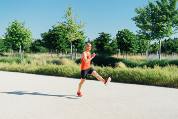 Young athletic man running at park