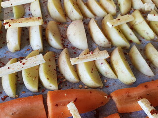 sliced potatoes and carrots with butter ready to fry