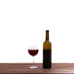 Glass and bottle of red wine unusually on wooden background.