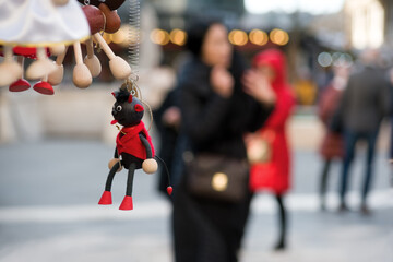 Toy devil against blurred woman walking in the city illustrating mood or behavior