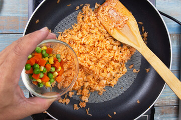 Chef pouring carrot,green bean and corn for cook fried rice