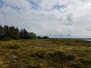 Obraz premium long summer pasture with the seven sisters mountain formation in the background, nordland in northern Norway