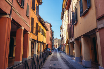 Narrow street with old residential buildings in historic part of Bologna city, Italy