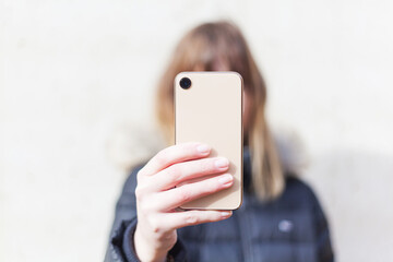 Woman holds smartphone at camera depth of field instagram social media communication range lifestyle technology success no branding copy space