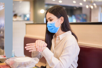 Woman is eating in Restaurant with social distancing protocol while lockdown City due to ...